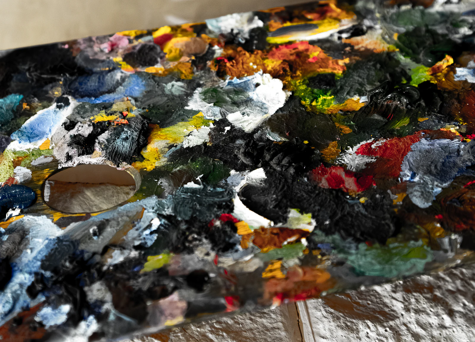 A well-used artist&rsquo;s palette crusted with thick mounds of oil and acrylic paint.