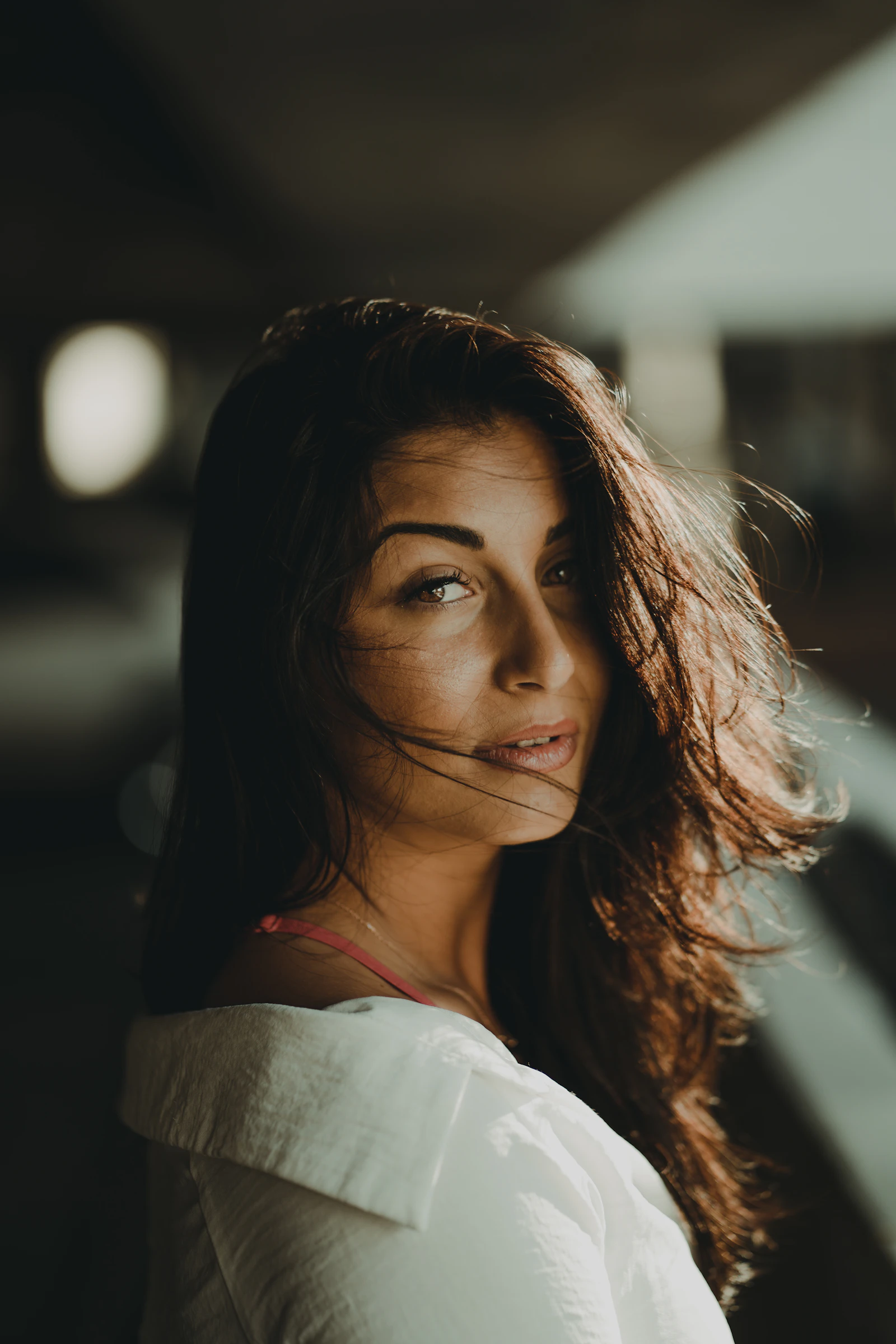 Warm directional light falling across one side of a woman&rsquo;s face, leaving the other side in shadow.
